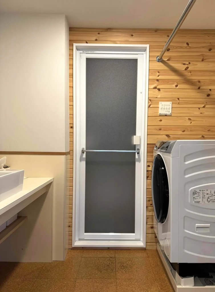 洗面台と洗濯機の奥にある浴室の扉