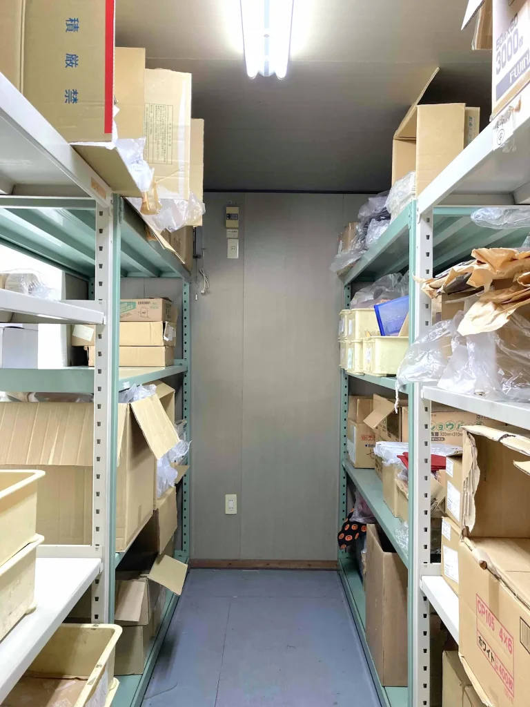両側の棚に物が置かれている倉庫