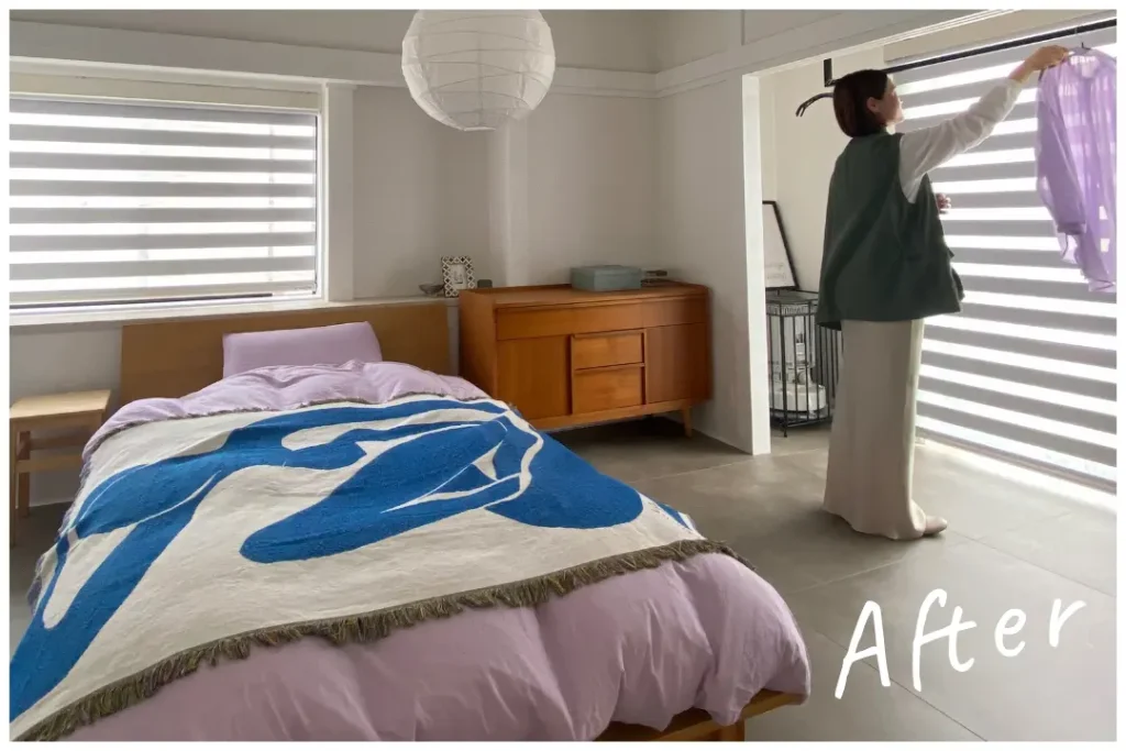 物が少ないベッドルーム。整えられたベッドと棚が置かれている。