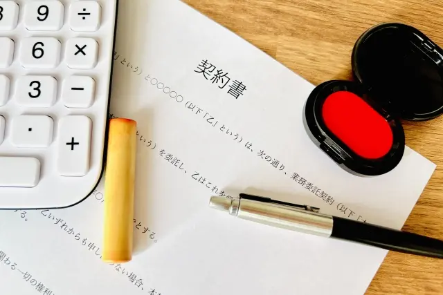 契約書と印鑑、朱肉、ペン、電卓