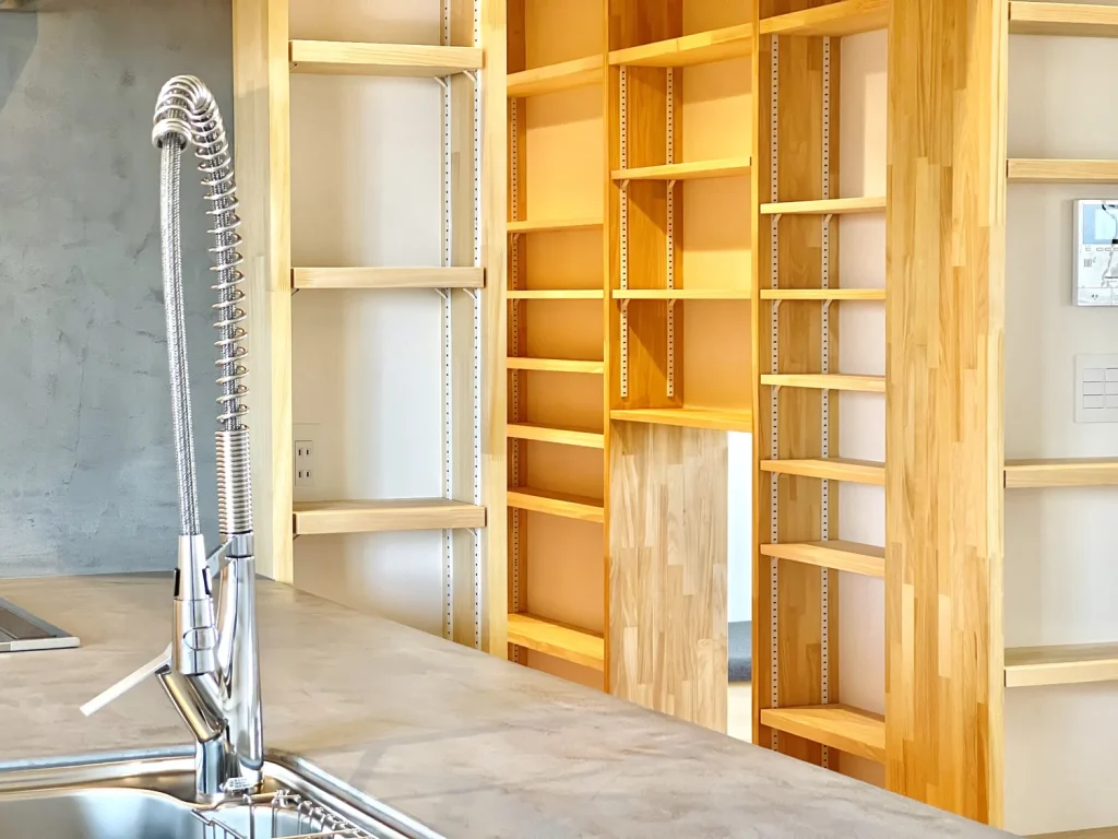 キッチンの水道とその奥にある木製の棚