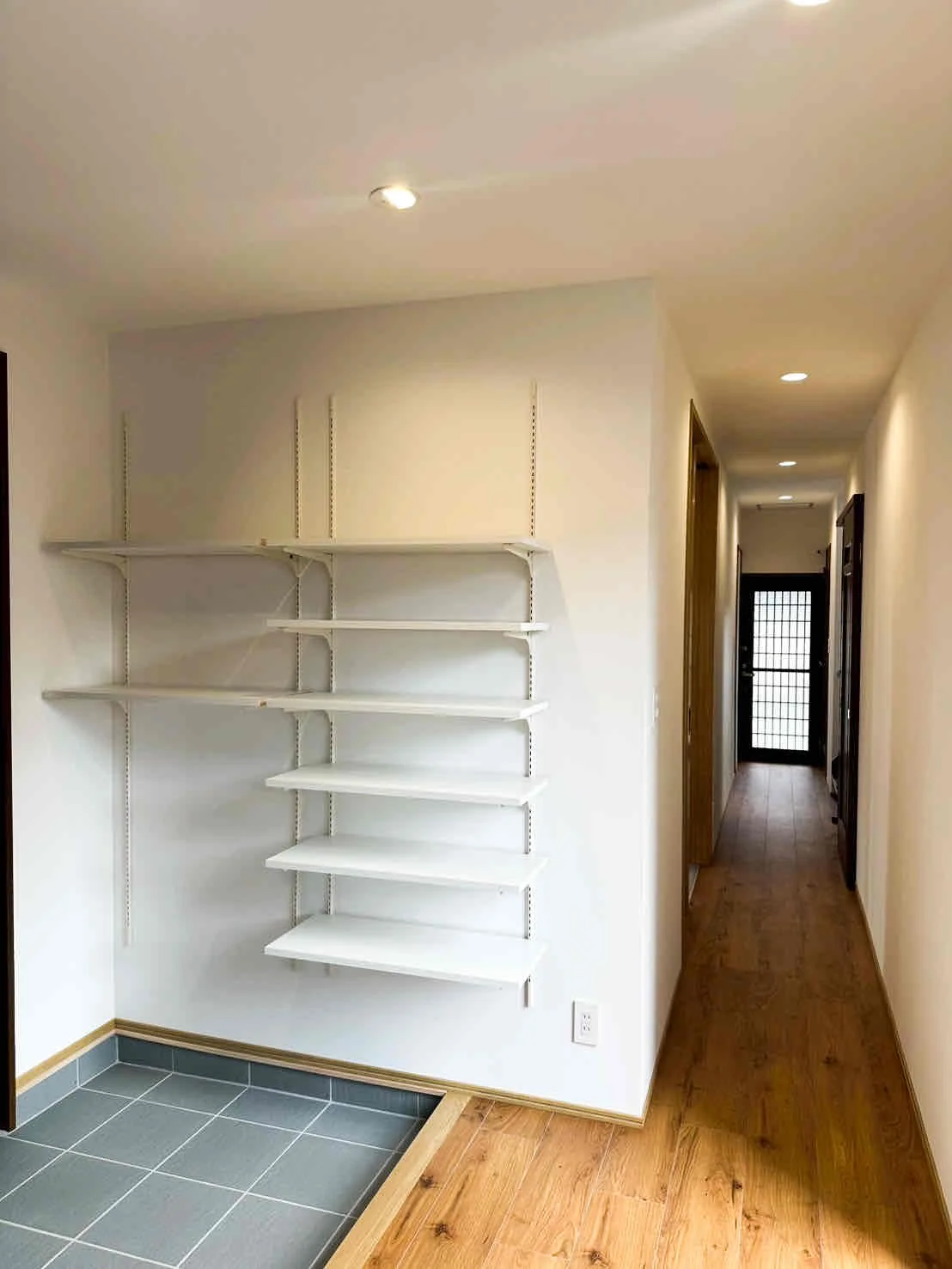 リフォーム後の玄関。壁には靴用の棚が取り付けられている。