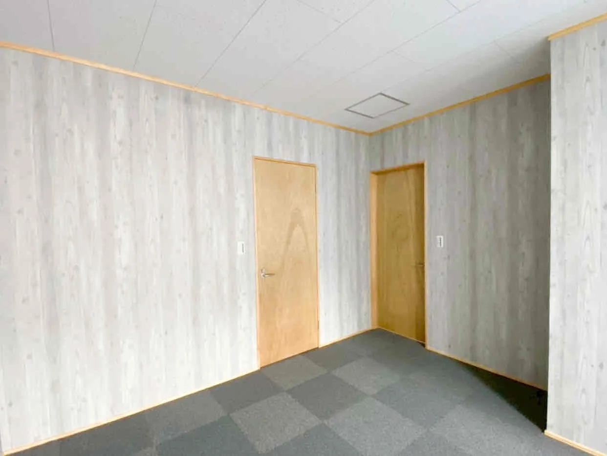 リフォーム後の室内。落ち着いた雰囲気の壁紙とシンプルなドア。