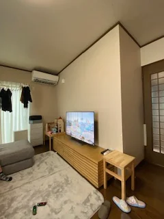 リフォーム前のリビング。テレビ台とテレビが置かれている、窓際に洗濯物が干されている。