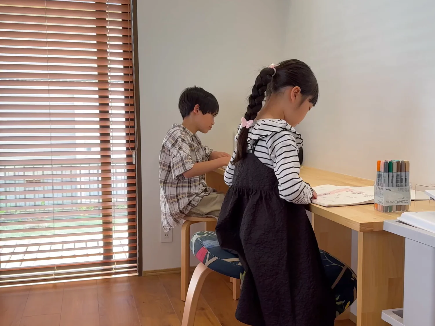 学習机に座っている子供二人