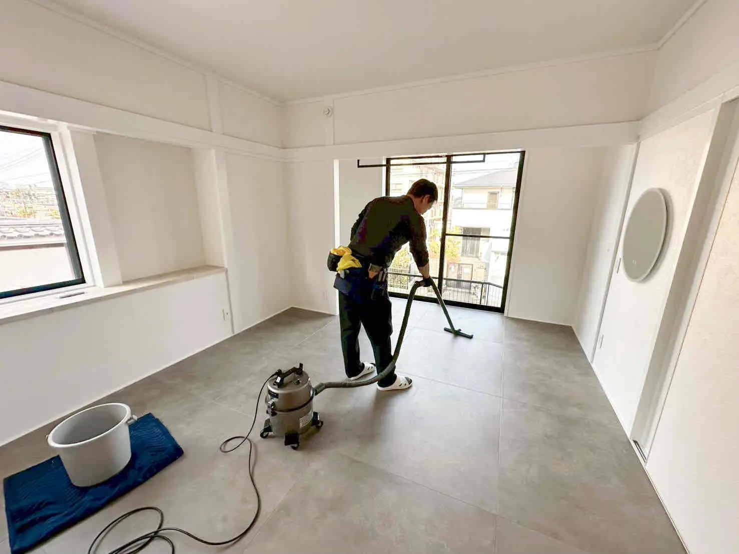 工事完了後の室内に掃除機をかける男性