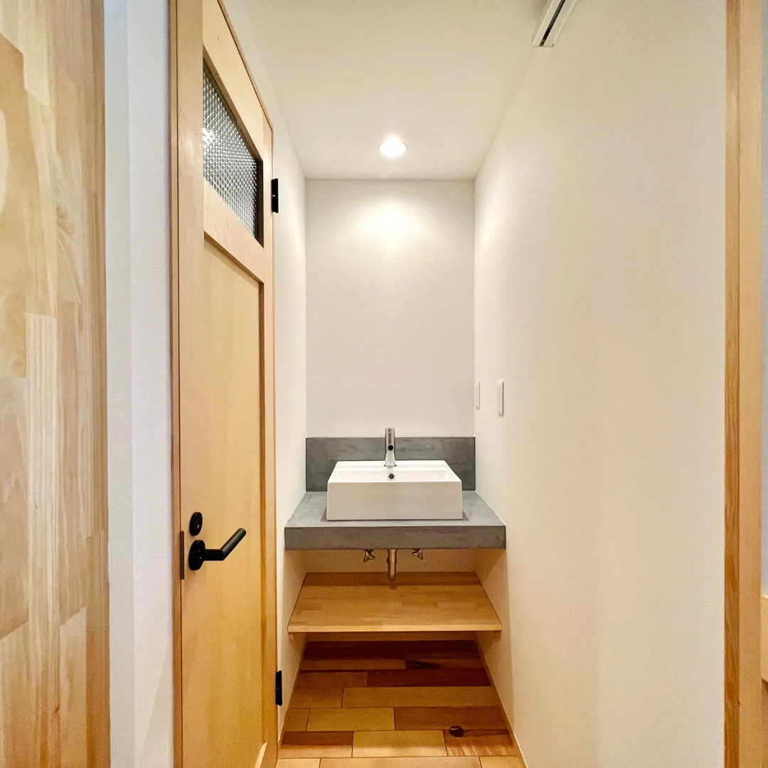 リフォーム後の洗面台。通路の奥にあり、その手前にはドアがある。